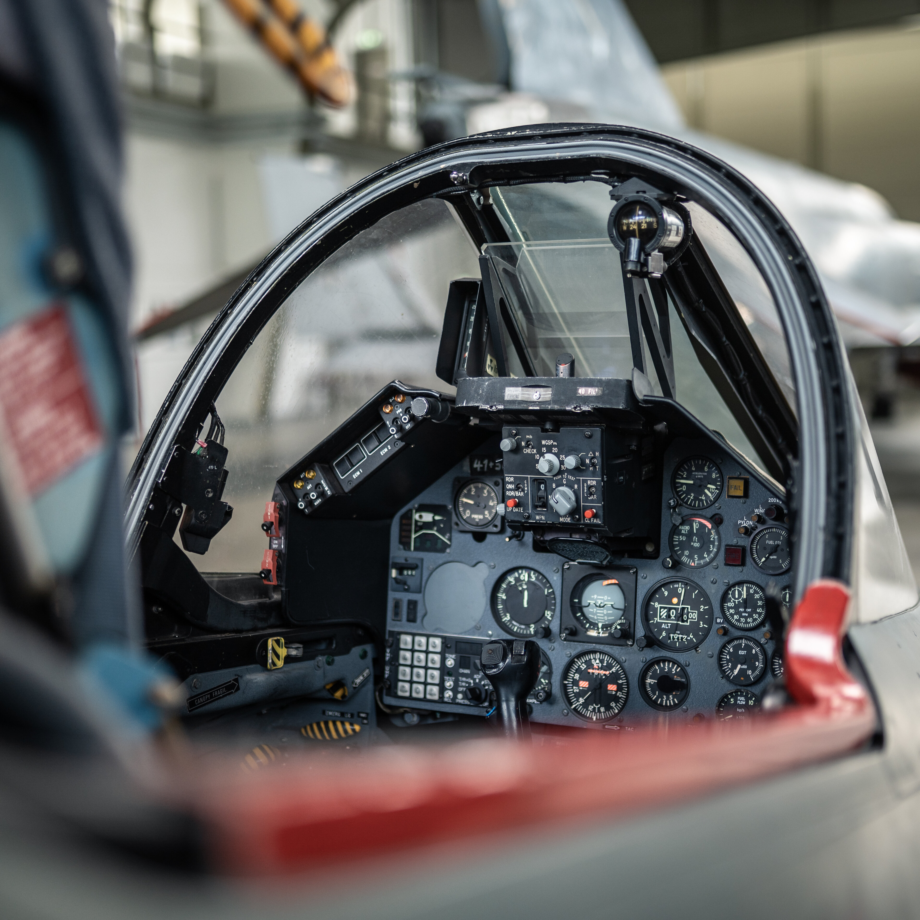 View of the open cockpit of an Aero L-39 Albatros, featuring an analogue instrument panel and an ejector seat. 