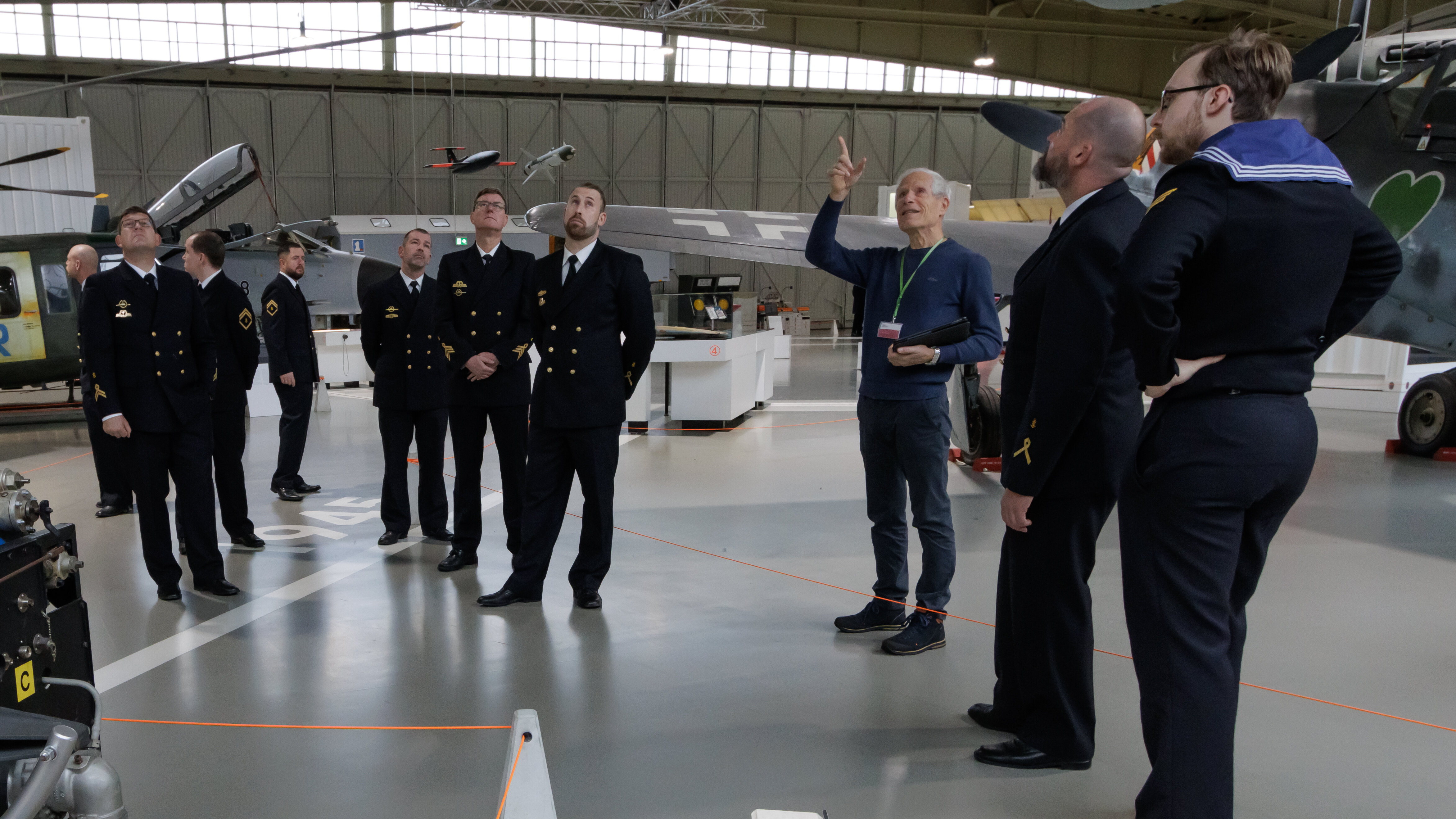 Eine Gruppe von Marinesoldaten steht im Hangar 3. Ein Guide weist nach oben zur Decke. 