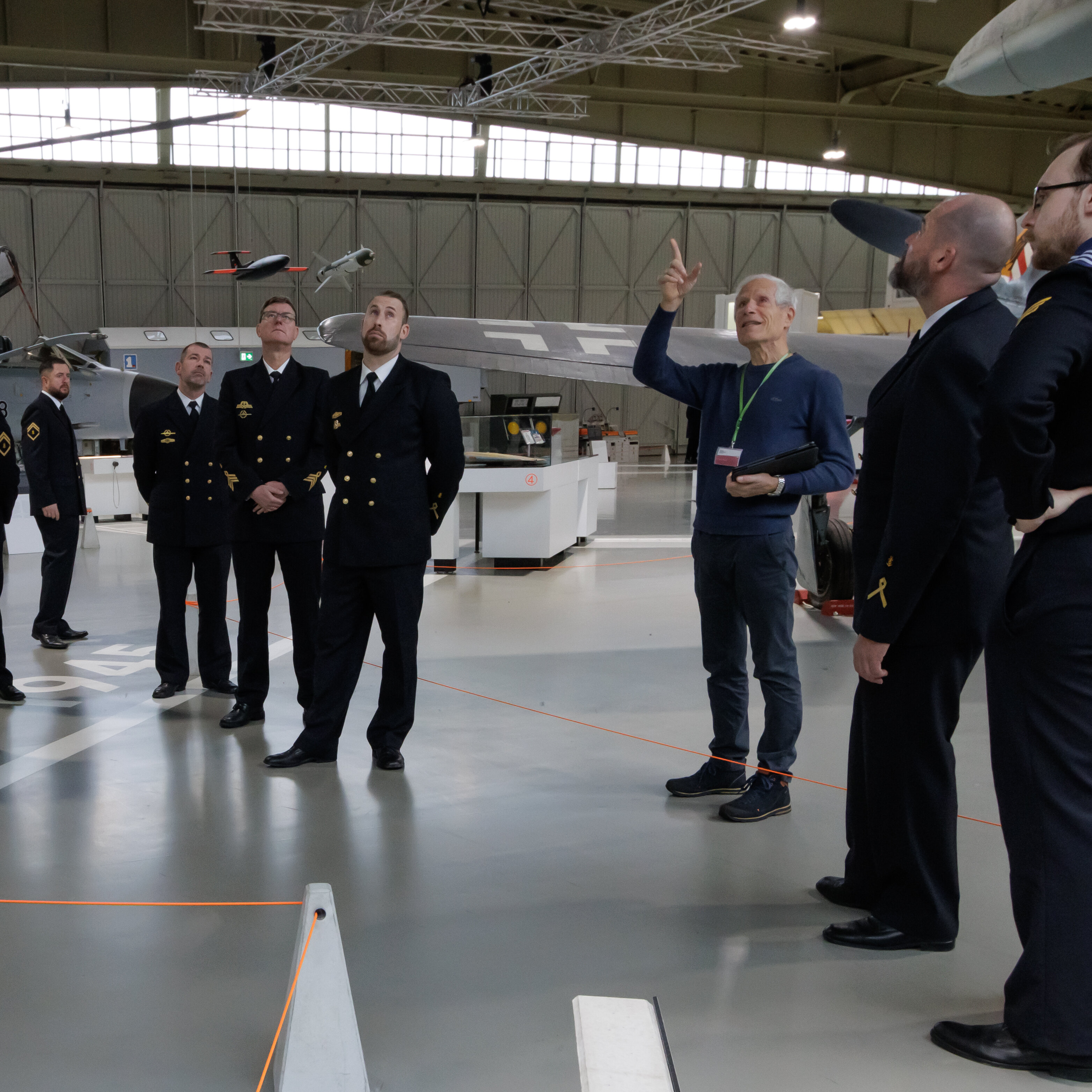 Eine Gruppe von Marinesoldaten steht im Hangar 3. Ein Guide weist nach oben zur Decke. 