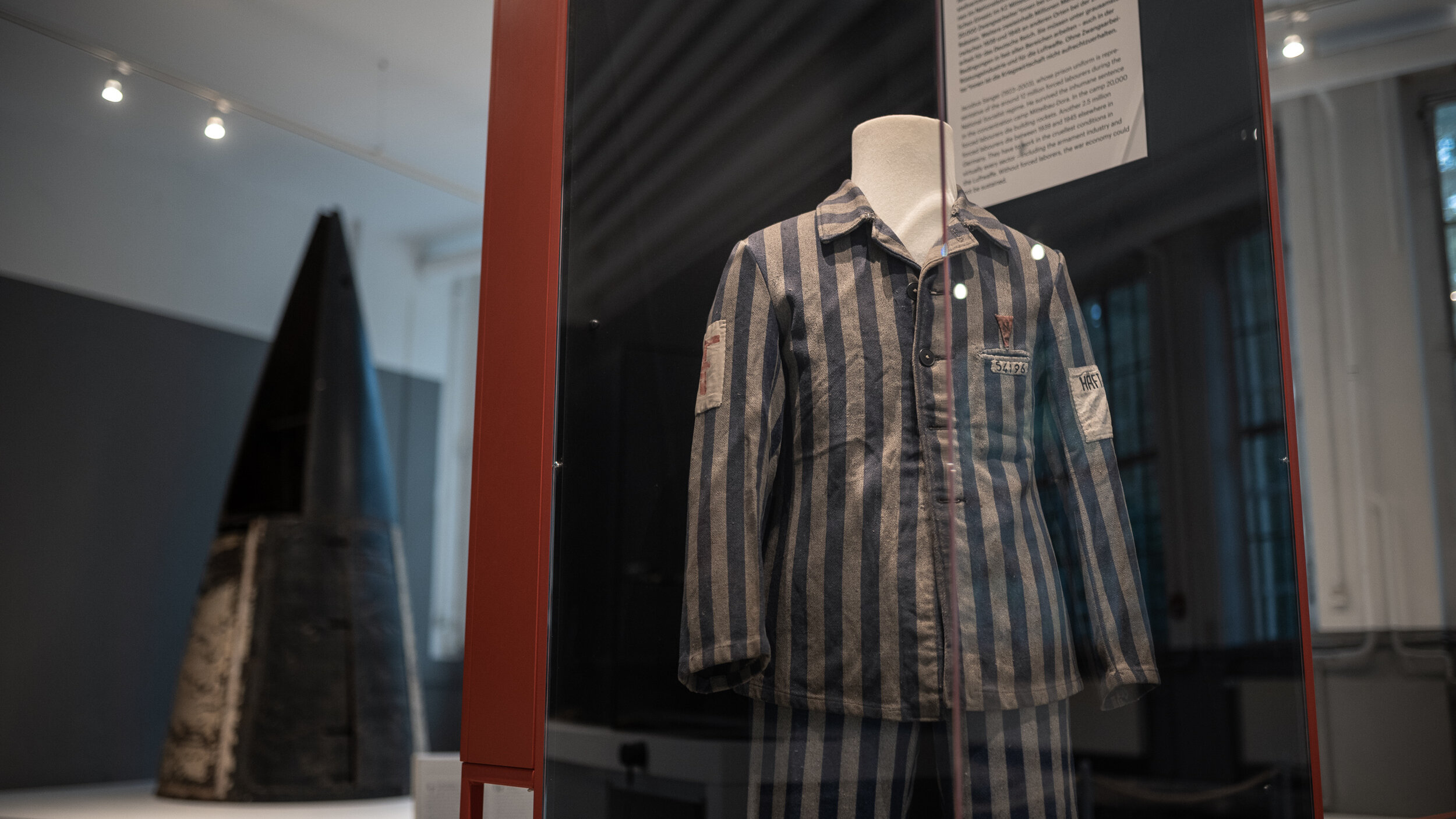 Vitrine mit der Häftlingsuniform eines KZ-Insassen, der bei der V2-Produktion in Mittelbau-Dora eingesetzt war.  