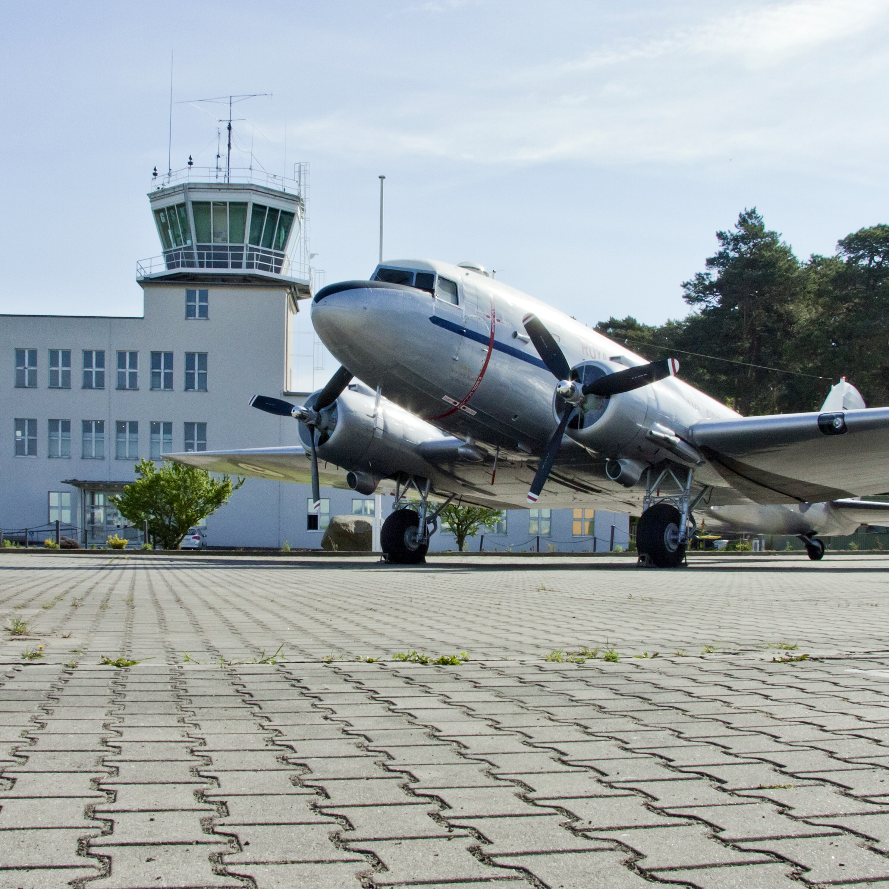 Auf dem Bild ist ein Flugzeug vor dem Towergebäude zu sehen.