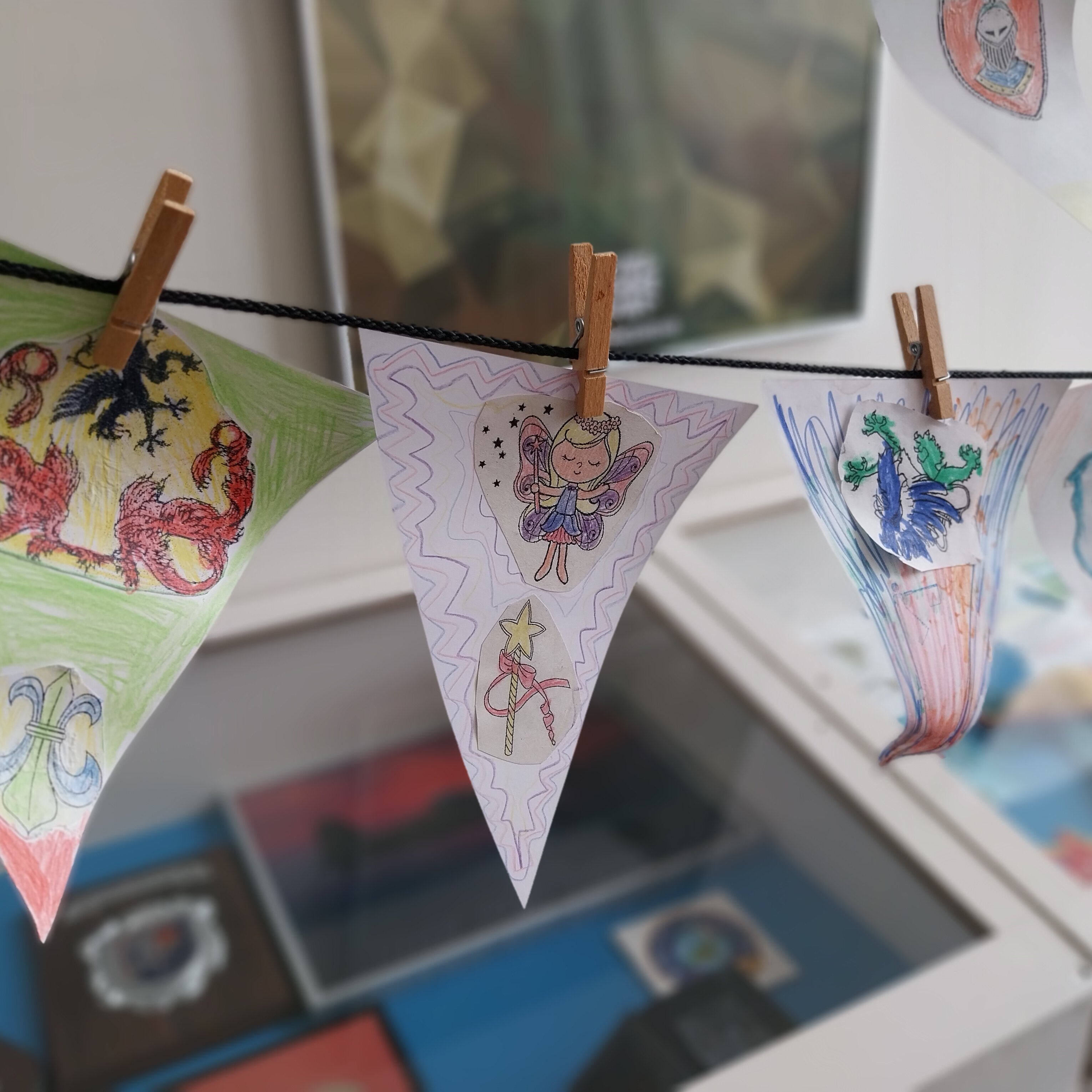 Bunte Wimpel mit verschiedenen Symbolen hängen mit Wäscheklammern befestigt auf der Leine. 