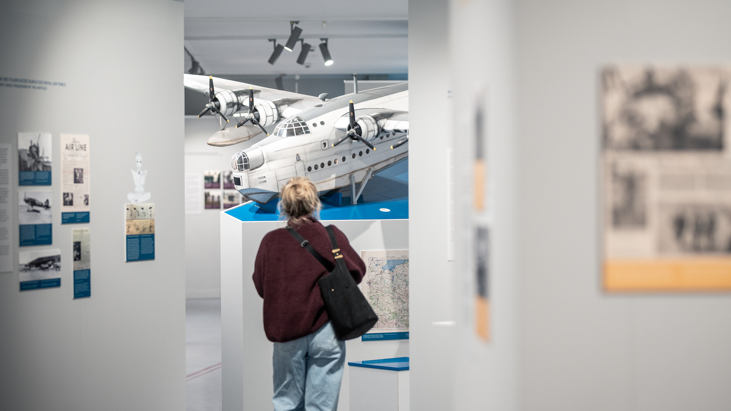 Eine Besucherin läuft durch die Ausstellung zur Flugplatzgeschichte mit dem Titel „You can’t miss Gatow“. 