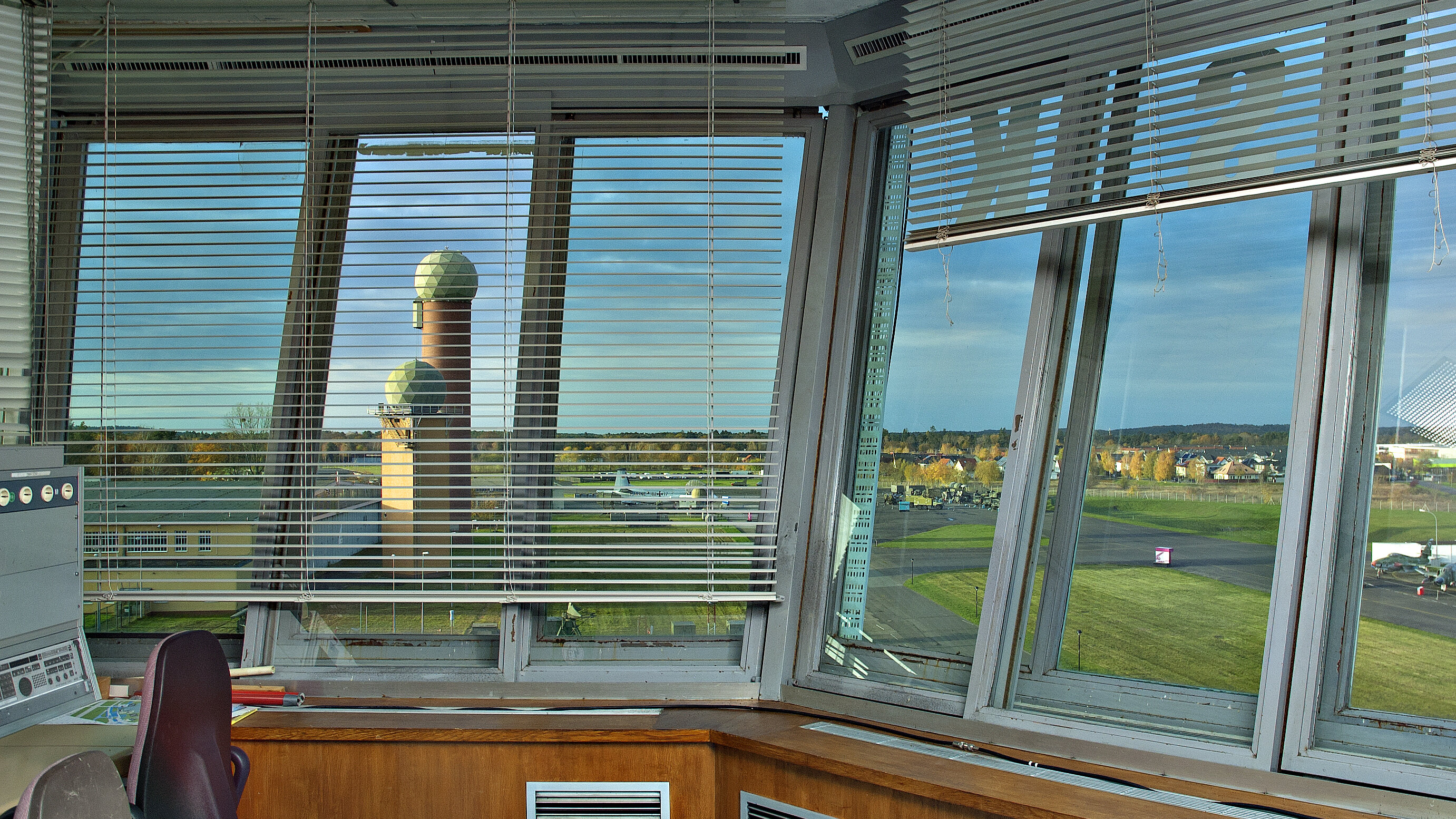 Blick durch die Fenster der Towerkanzel auf das Gelände mit Hangar 4 und Radartürmen. 