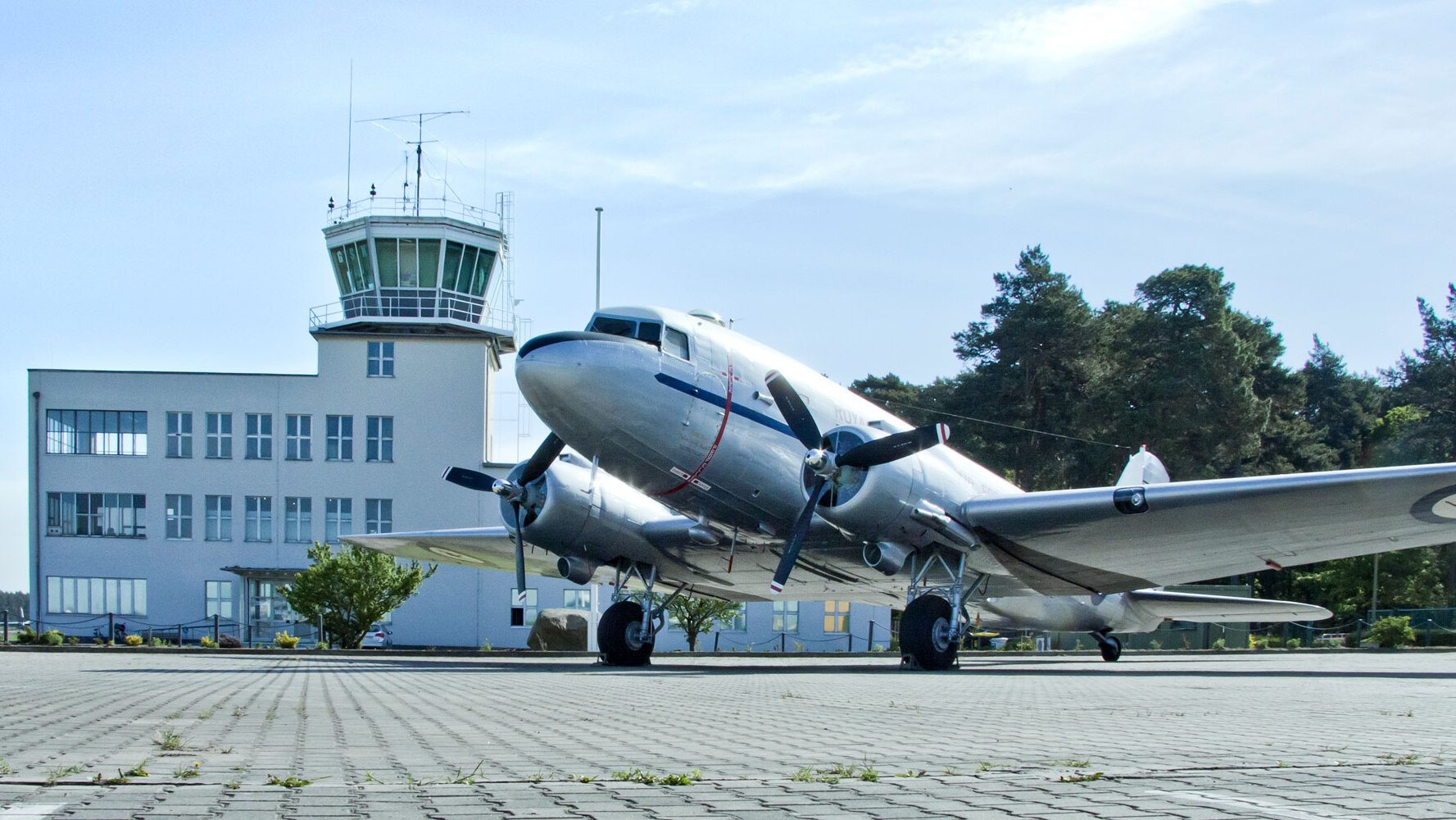 Auf dem Bild ist ein Flugzeug vor dem Towergebäude zu sehen.