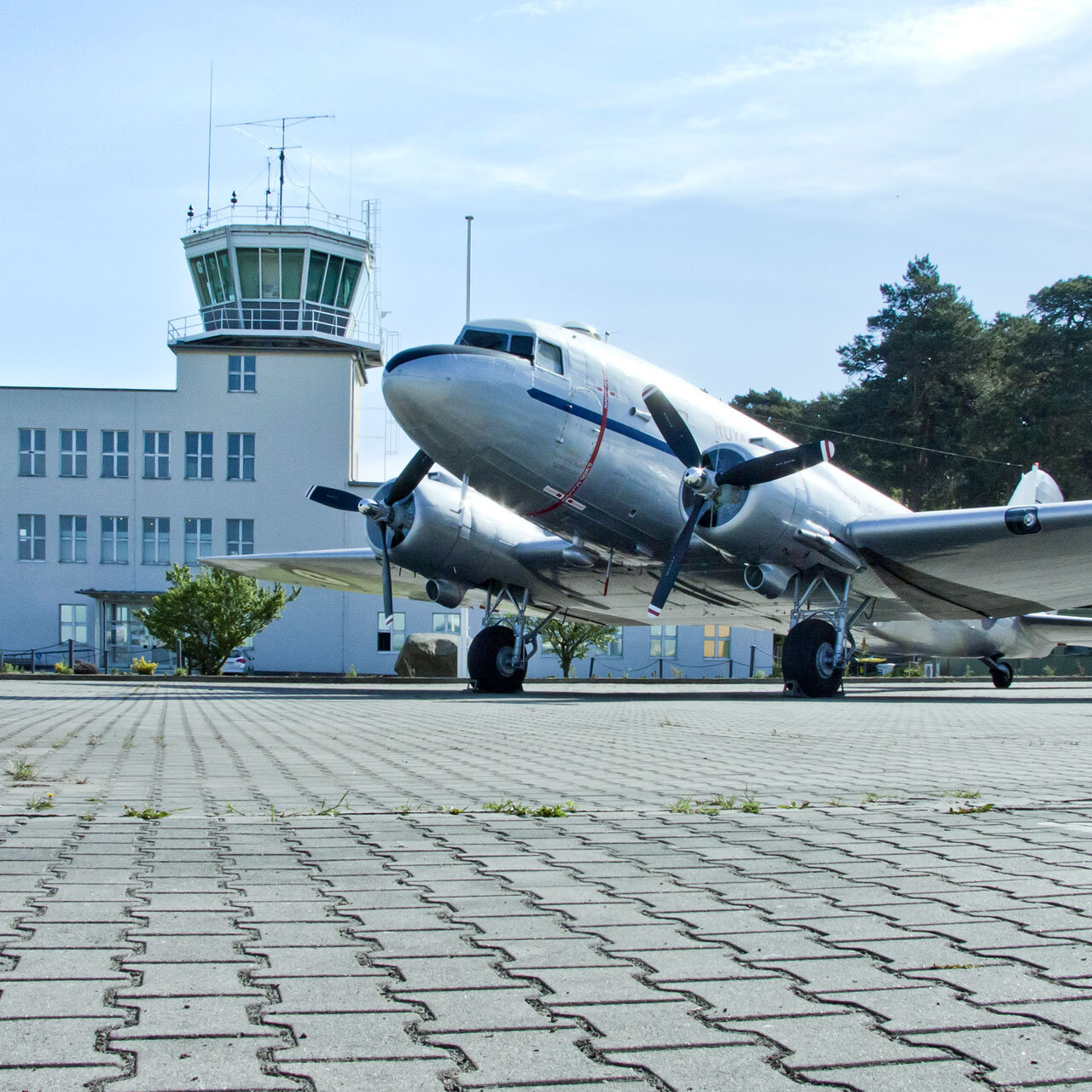 Auf dem Bild ist ein Flugzeug vor dem Towergebäude zu sehen.