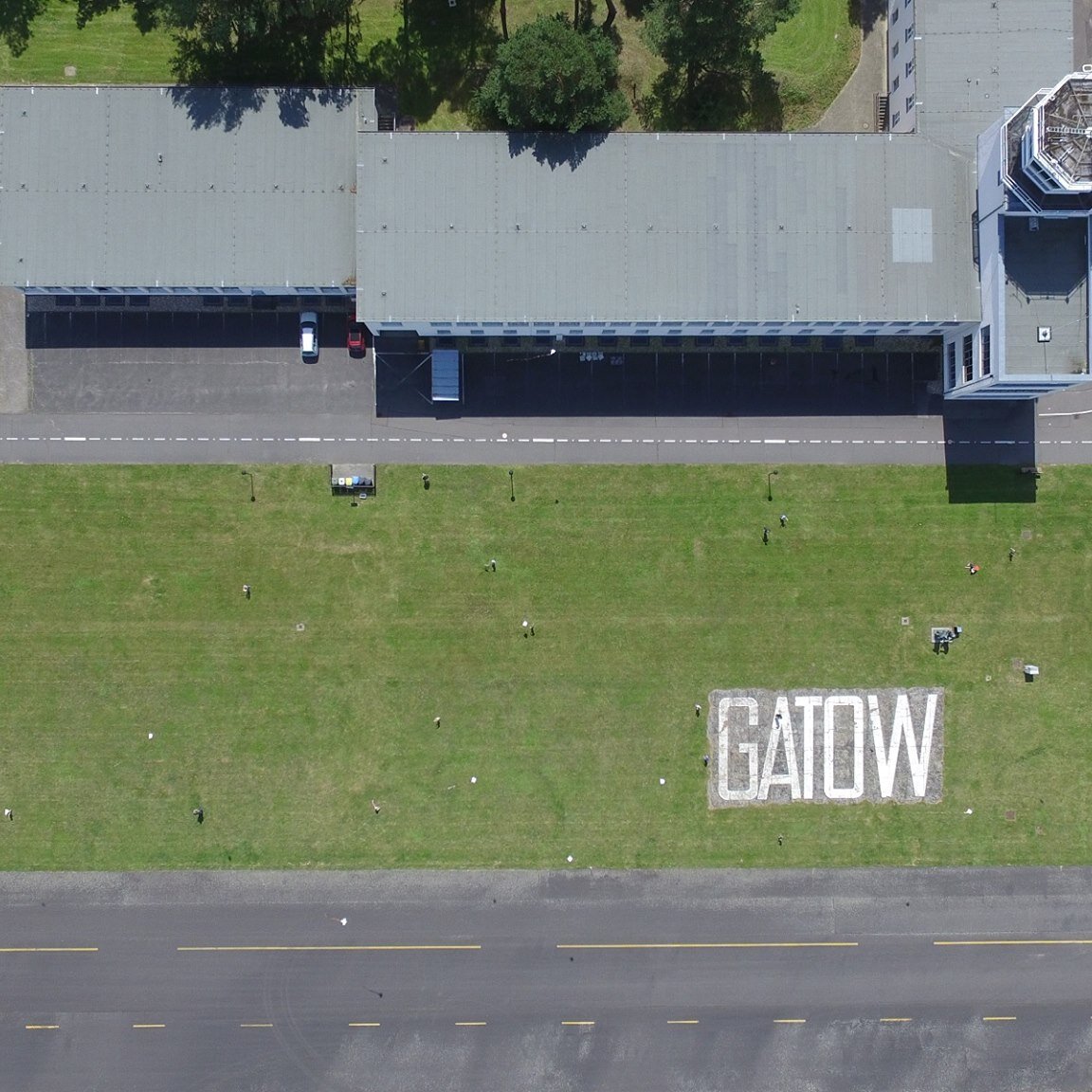 Luftaufnahme des Flugplatzes Berlin-Gatow; auf der Wiese steht groß „GATOW“, unten verläuft die Rollbahn. 
