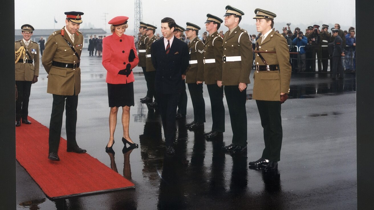 Britische Ehrengarde mit dem Kronprinzenpaar auf dem Flugfeld im Regen. 